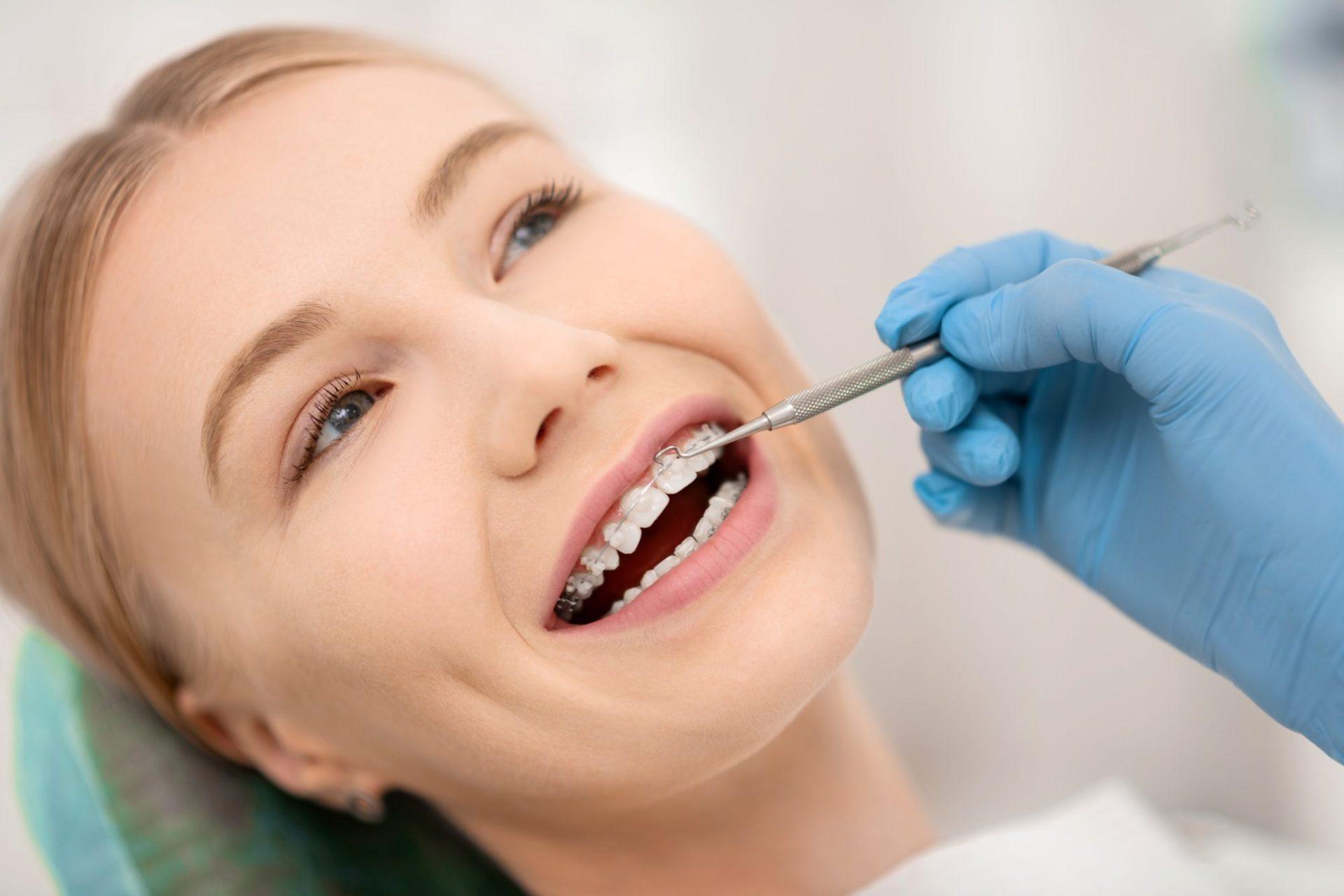 patient fixing her orthodontic braces in dental clinic